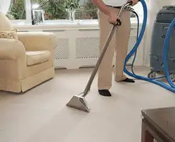 Carpet cleaning professional removing dirt and stains with a hot-water extraction tool in a home, Honolulu, HI.