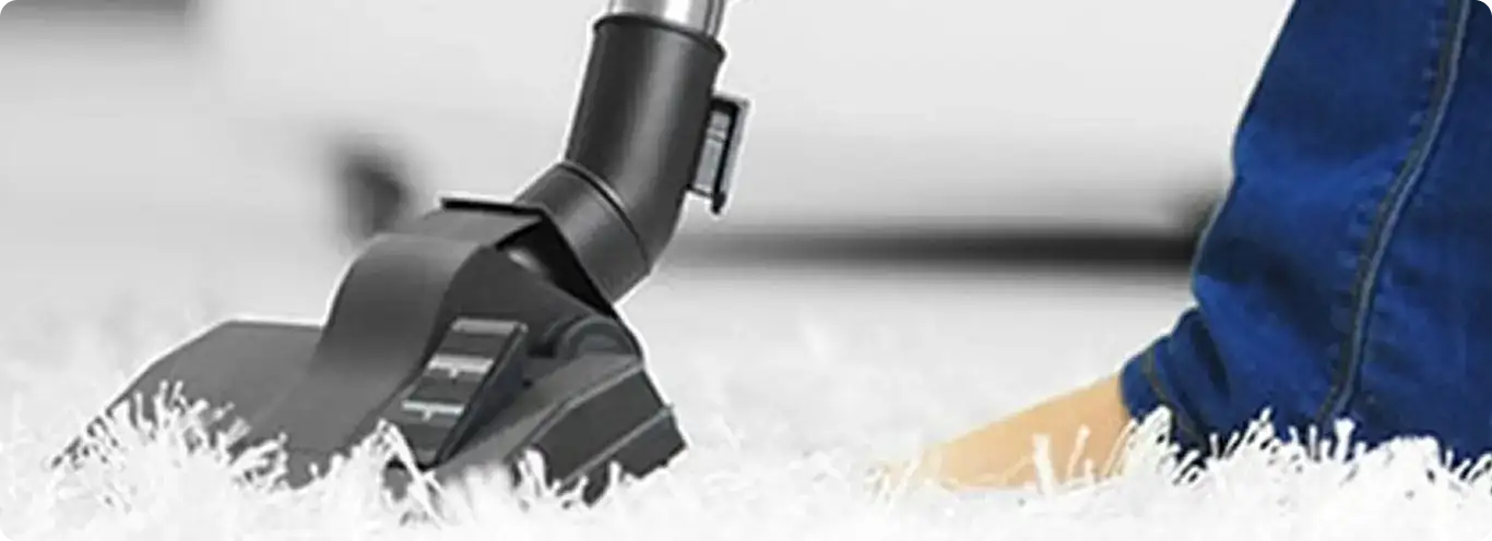 Close-up of a professional vacuuming a white carpet in Waimanalo.